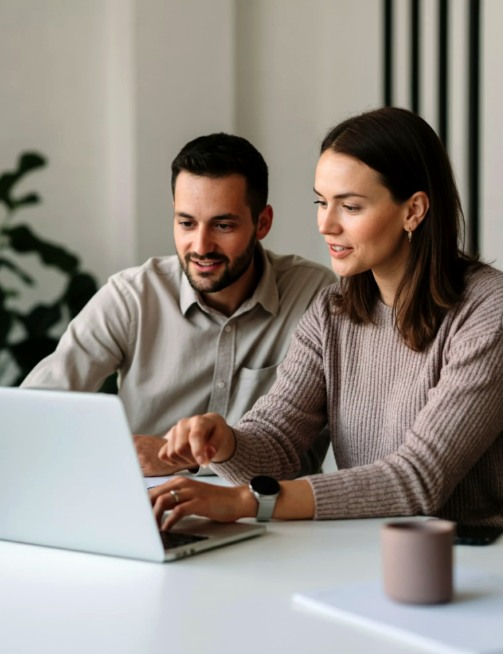 Two people reviewing a payment application together on a laptop